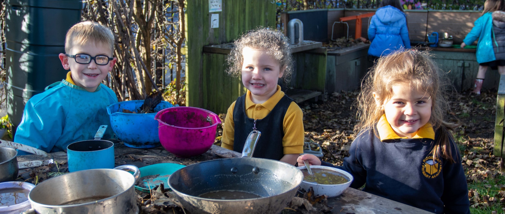 Foundation Stage children playing in our mud kitchen